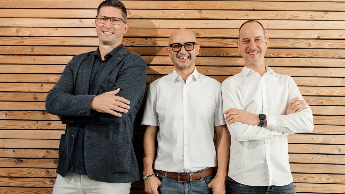 Die Eigentümer und die Geschäftsführung von digibon vor der Lärchenholzwand in Dornbirn
